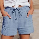 Sommerlig antrekk med lyseblå shorts, hvit topp og armbånd for avslappet stil.