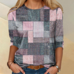 Stilig kvinne i geometrisk patchwork topp og mørkeblå jeans med elegante tilbehør.