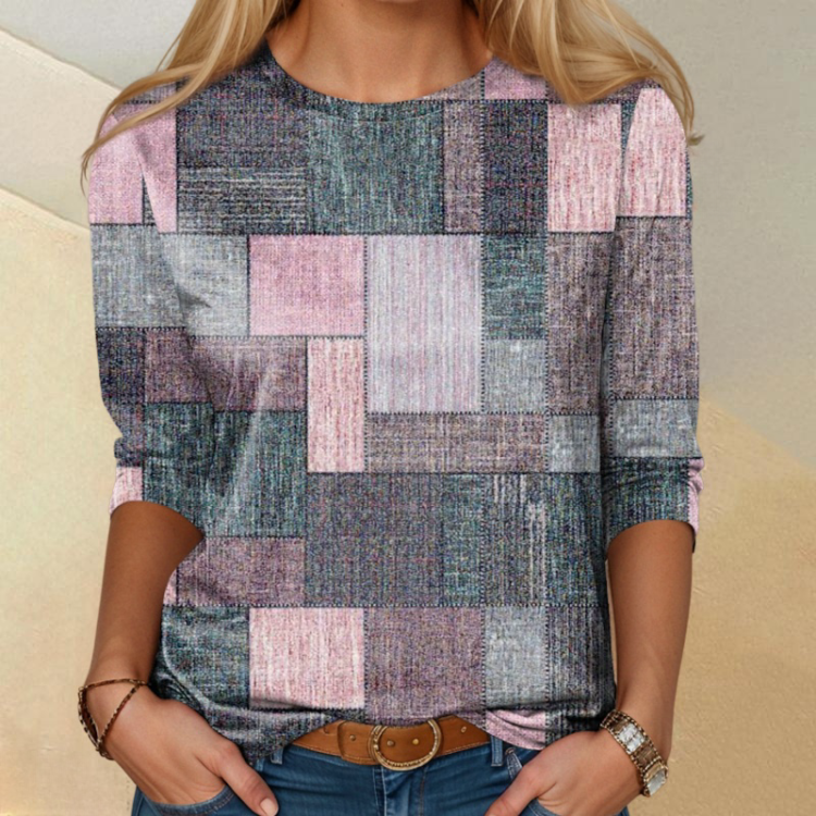 Stilig kvinne i geometrisk patchwork topp og mørkeblå jeans med elegante tilbehør.