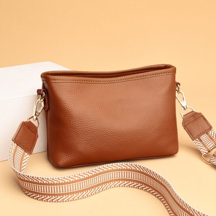 Stilig brun skinn crossbody veske med moderne design og luksuriøse detaljer.