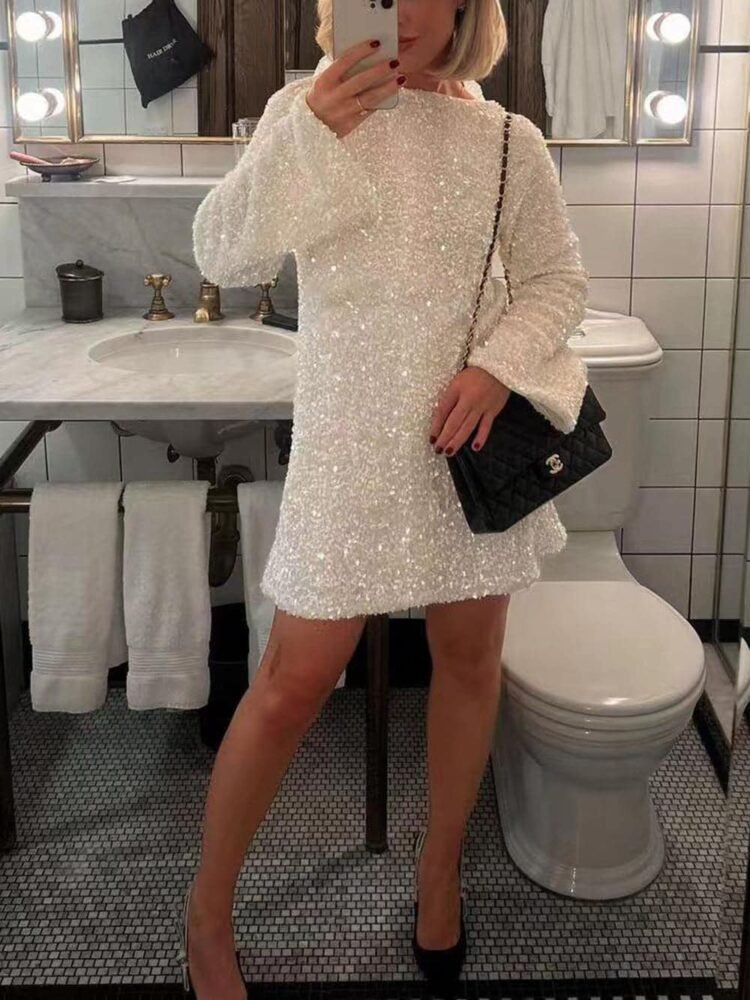 Elegant kvinne tar speil-selfie i moderne bad med hvit glitterkjole.