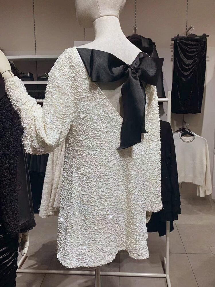 Elegant hvit kjole med svart sløyfe i moderne butikk - fashionably elegant.