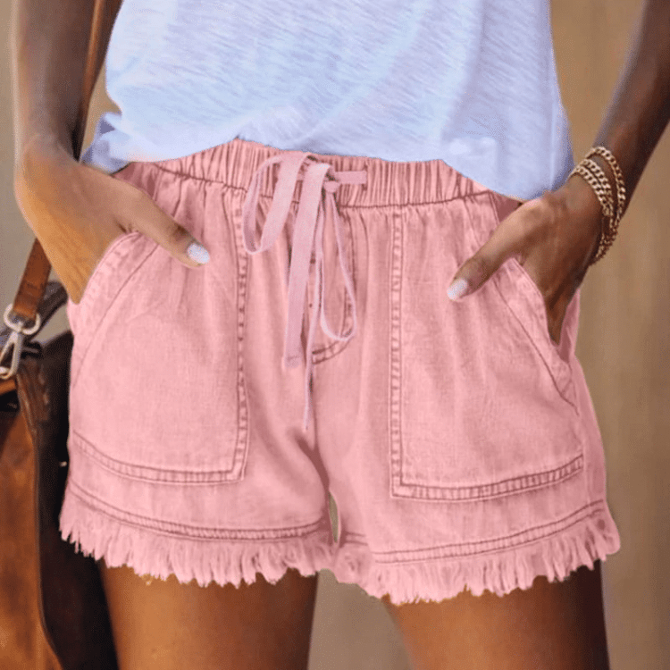 Sommerlig antrekk med laksrosa shorts, ruffle-trim og armbånd - Feminint og trendy.