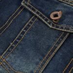 Mørk blå denim lomme med knapp og detaljert søm, twill-vevd stoff.