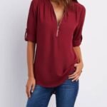 Maroon bluse og blå jeans antrekk med elegant glidelåsdetalj.