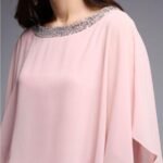 Elegant rosa bluse med perleutsmykning og silkestoff til spesielle anledninger.