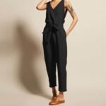 Stilfull svart jumpsuit med loafers - elegant stil og selvsikker holdning.