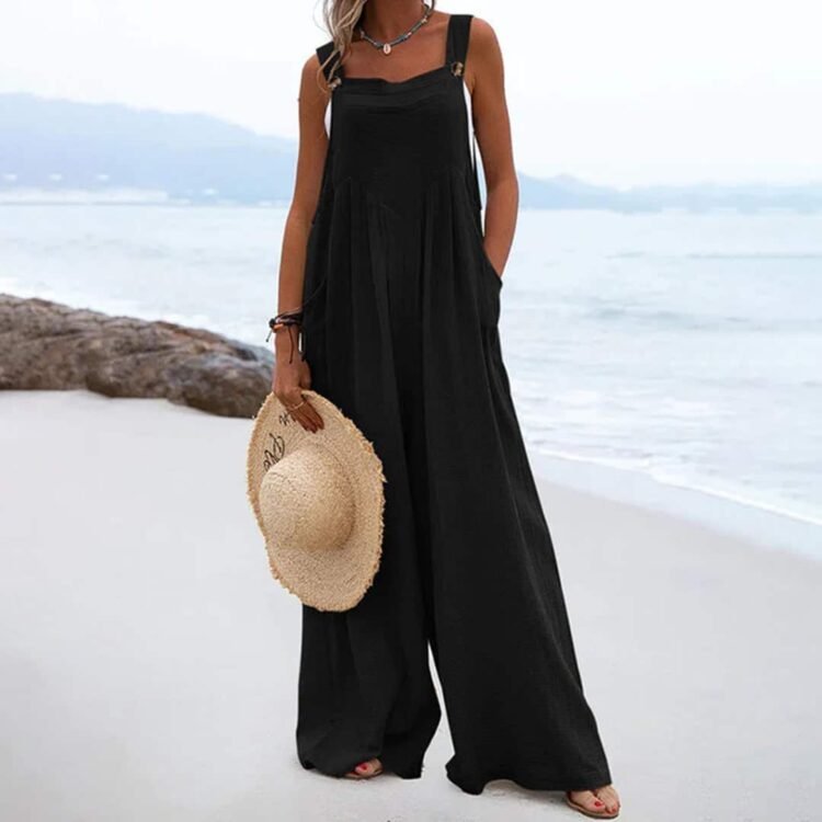 Stilig jumpsuit på stranden med stråhatt - elegant og avslappet beach outfit.