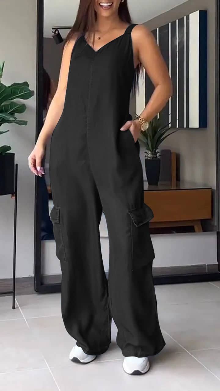 Stilig jumpsuit i moderne rom med planter og smilende person.