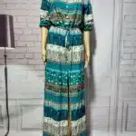 Elegant teal dress on mannequin in modern interior.