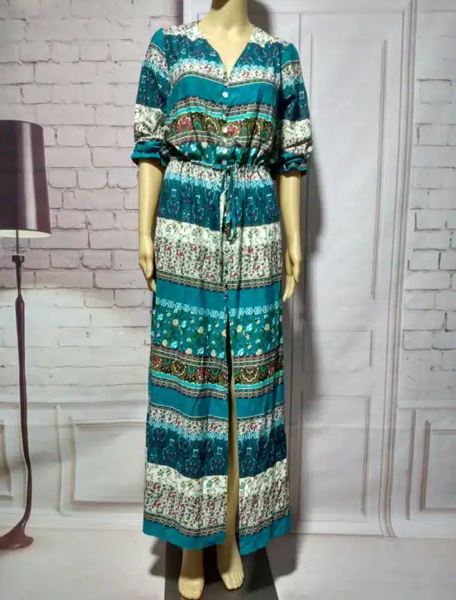 Elegant teal dress on mannequin in modern interior.